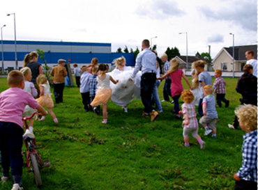 Photo of a group of kids and adults playing outside in a field